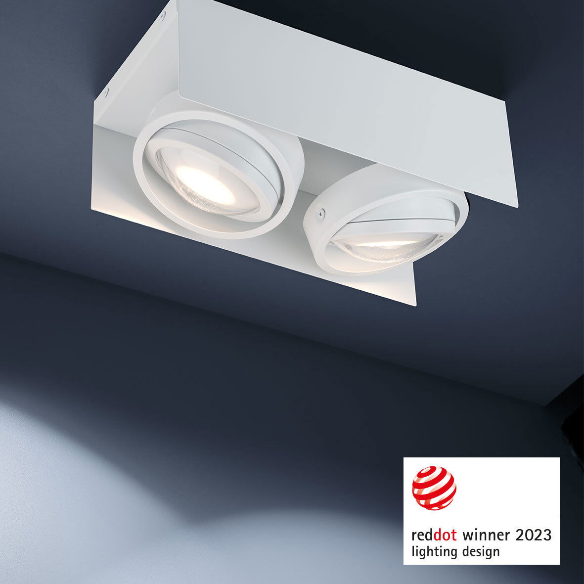 Moderne LED Aufbauleuchte mit zwei runden Strahlern, Deckenansicht, ausgezeichnet mit dem Red Dot Award 2023.
