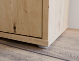 Nahaufnahme der unteren Ecke eines XL-Schuhschranks aus Holz mit sichtbaren Holzmaserungen und kleinen Füßen, Perspektive von unten.