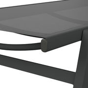 Nahaufnahme einer modernen Sonnenliege mit grauem Stoffbezug und stabilem Metallrahmen, seitliche Perspektive.