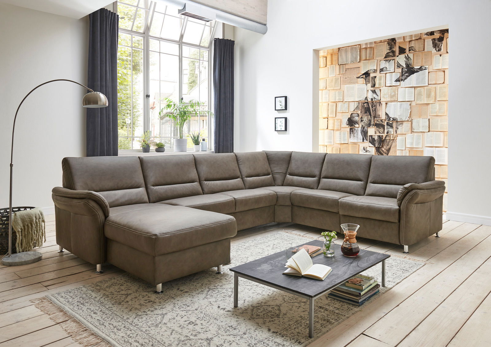 Moderne Polsterrundecke in einem hellen Wohnzimmer, Perspektive von vorne links.