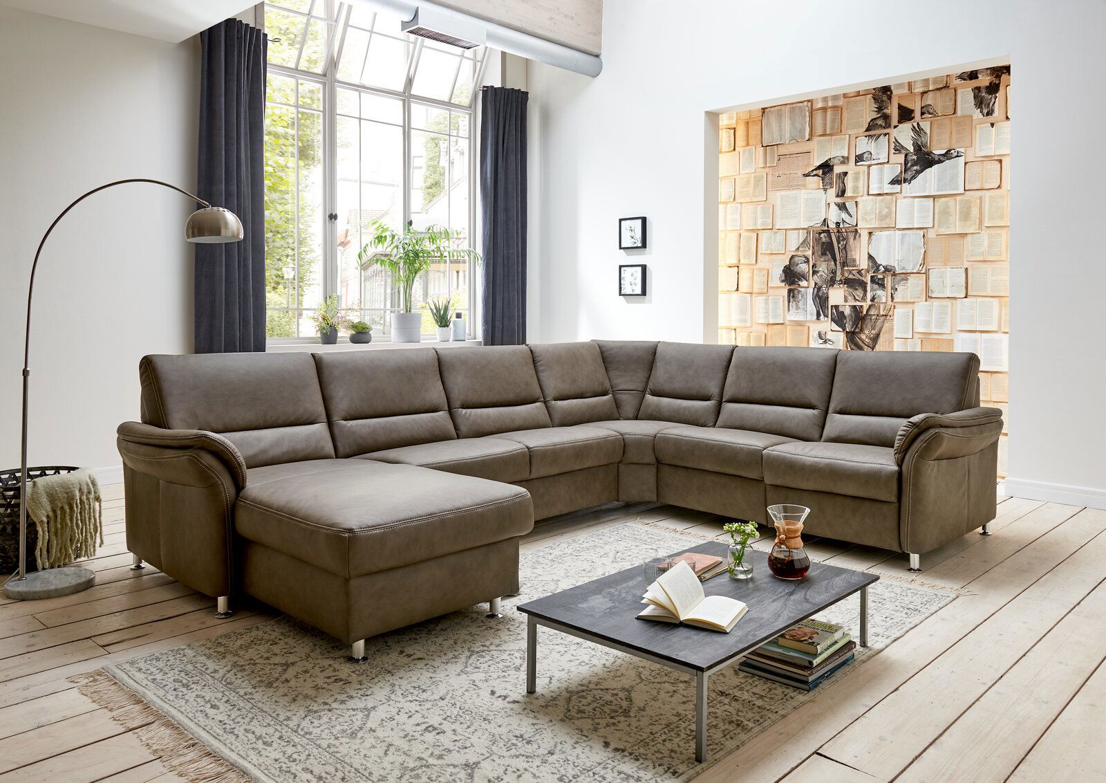 Moderne Polsterrundecke in einem hellen Wohnzimmer, Perspektive von vorne links.