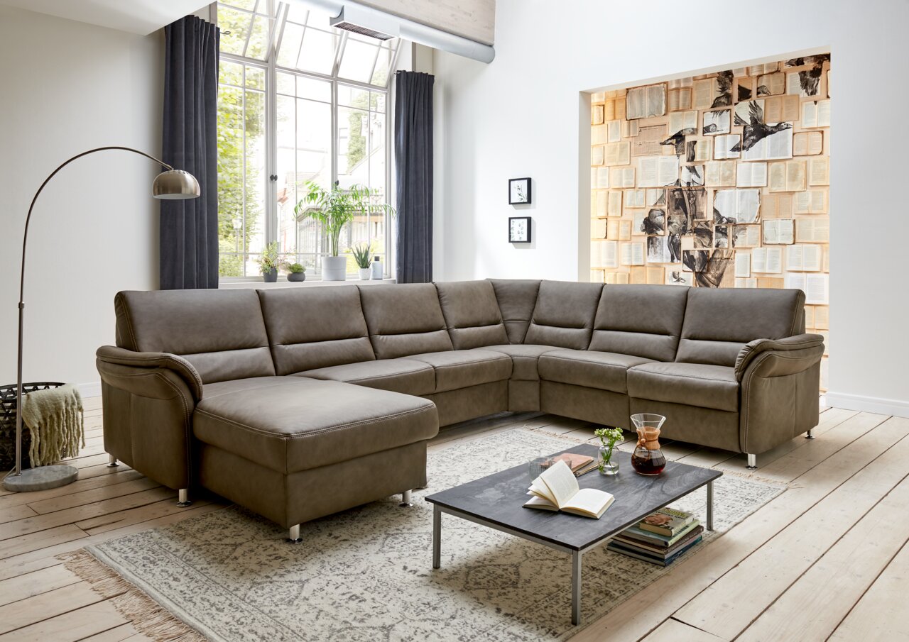 Moderne Polsterrundecke in einem hellen Wohnzimmer, Perspektive von vorne links.