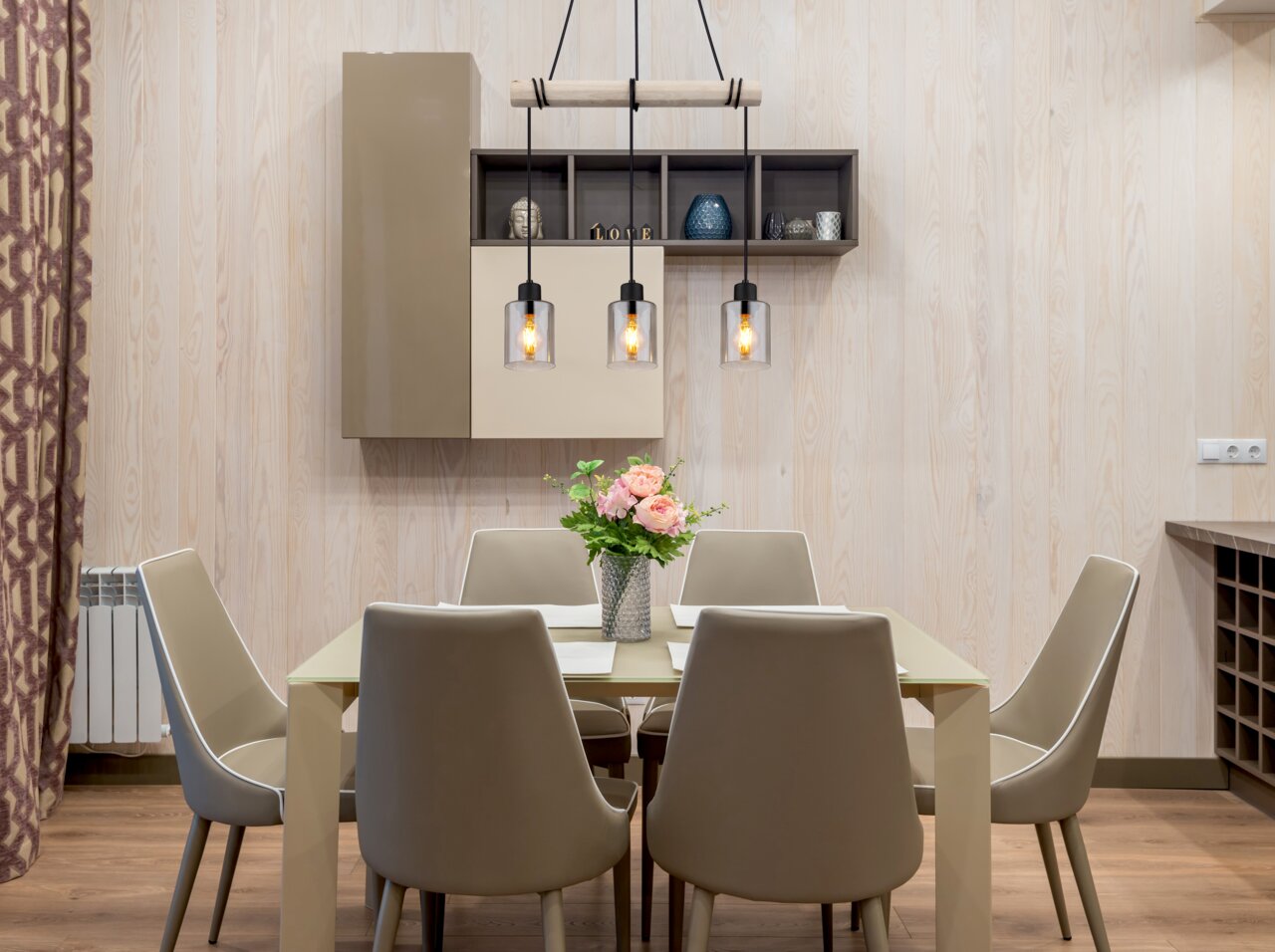 Moderne Hängeleuchte mit drei Glühbirnen über einem Esstisch, seitliche Perspektive