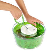 Salatschleuder Easy Spin in Grün, von oben fotografiert, mit einer Hand, die den Griff hält und einer anderen Hand, die den Deckel fixiert.