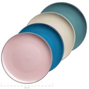 Vier runde Keramikteller in Pastellfarben (Rosa, Blau, Creme, Petrol) gestapelt, schräg von oben in Draufsicht, Durchmesser ca. 26 cm