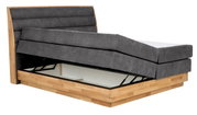 Boxspringbed met grijze bekleding en houten frame, zijaanzicht, gedeeltelijk geopend voor opbergruimte