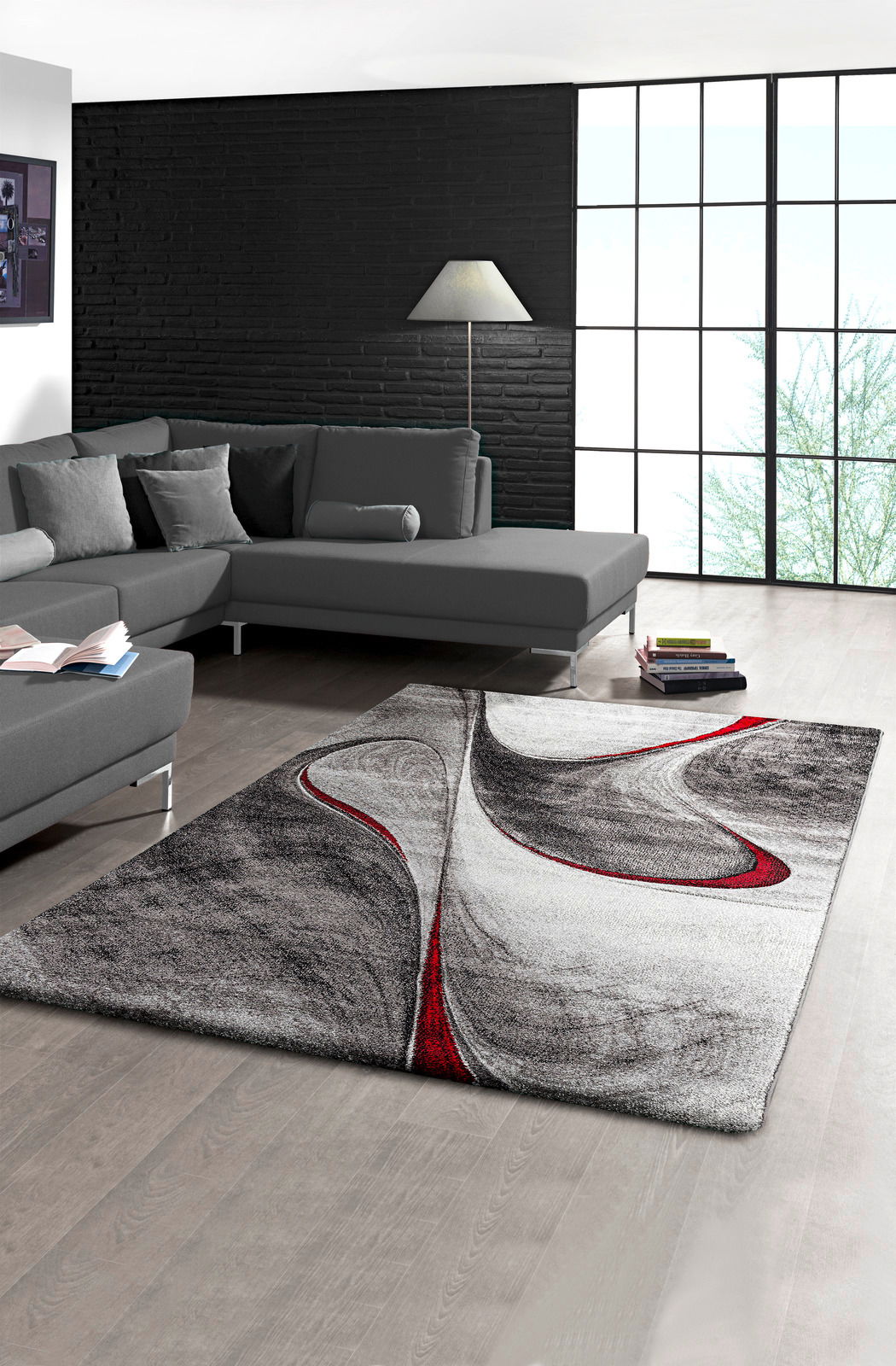 Moderner Teppich mit abstraktem Design in Schwarz, Weiß und Rot in einem stilvollen Wohnzimmer, Perspektive von oben.