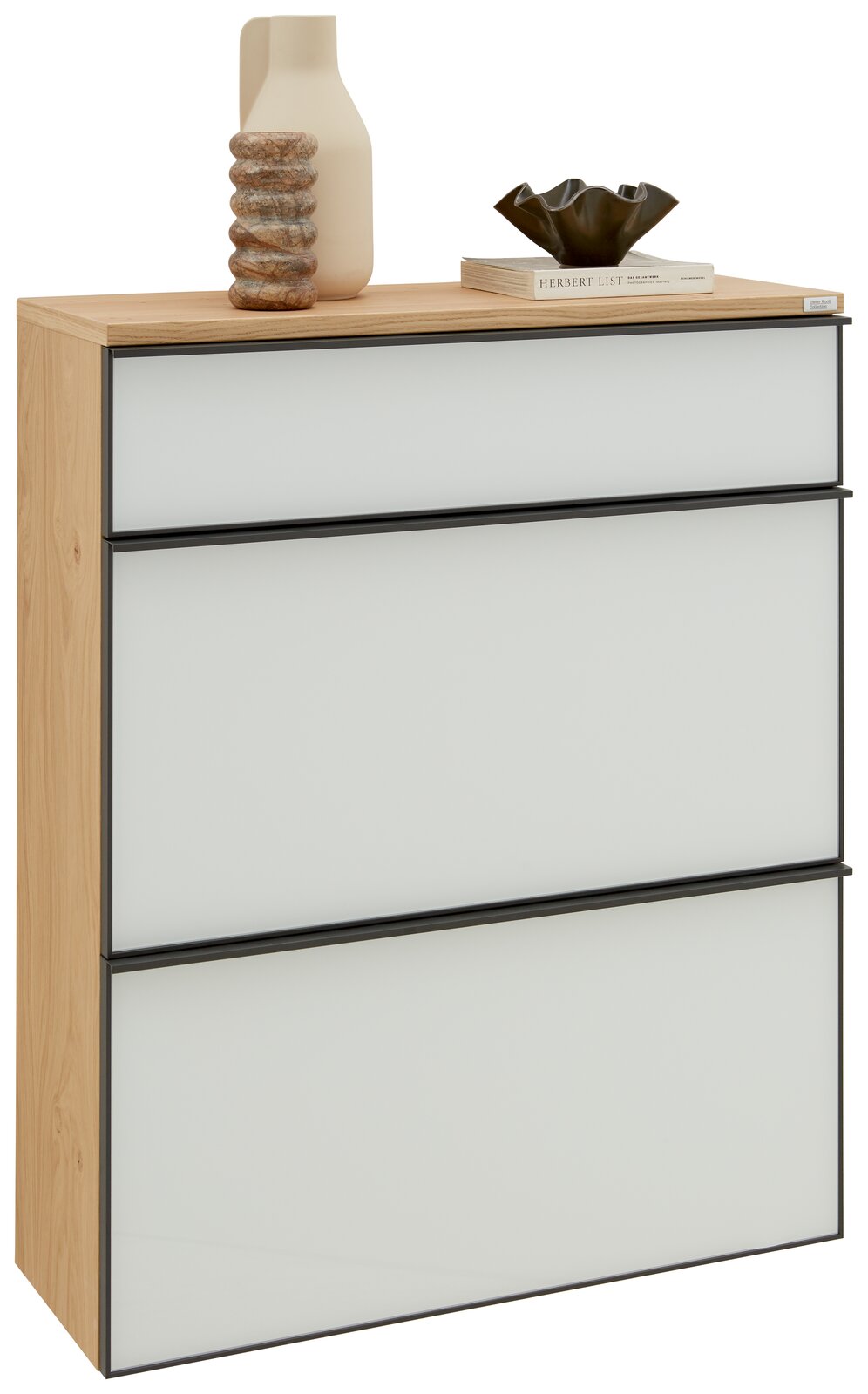 Moderner Hängeschuhschrank mit drei weißen Schubladen und Holzrahmen, dekoriert mit einer Vase und einem Buch, seitliche Perspektive.