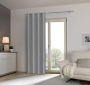 Grauer Ösenschal an einem Fenster in einem modernen Wohnzimmer, seitliche Perspektive