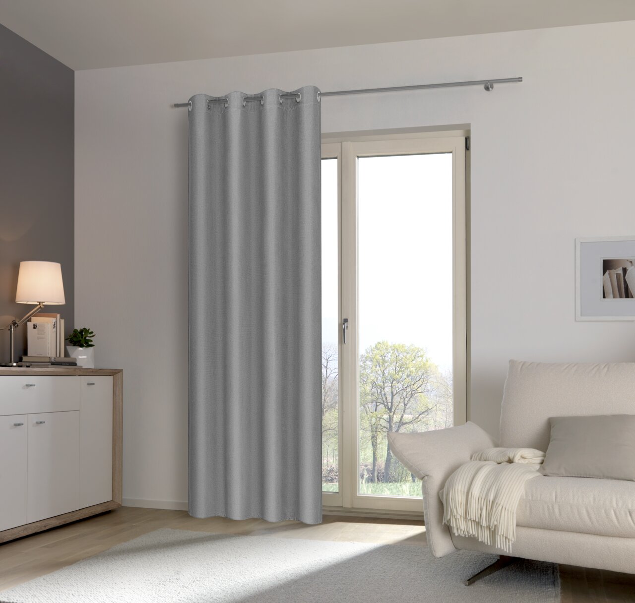 Grauer Ösenschal an einem Fenster in einem modernen Wohnzimmer, seitliche Perspektive