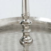 Nahaufnahme einer silbernen Etagere aus Aluminium mit strukturierter Oberfläche und elegantem Mittelstab, seitliche Perspektive.