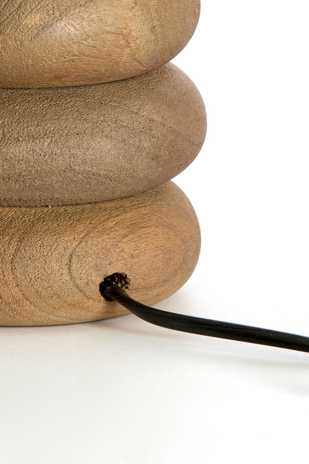 Nahaufnahme eines Lampenfußes aus Holz mit einem schwarzen Kabel, seitliche Perspektive