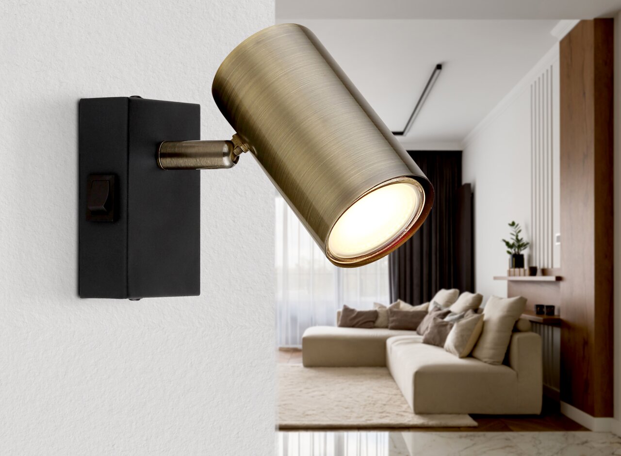 Globo Lighting Strahler ROBBY Wandstrahler in Altmessing-Optik, seitliche Perspektive, montiert an einer weißen Wand in einem modernen Wohnzimmer.