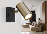 Wandstrahler in Altmessing-Optik, seitliche Perspektive, montiert an einer weißen Wand in einem modernen Wohnzimmer.
