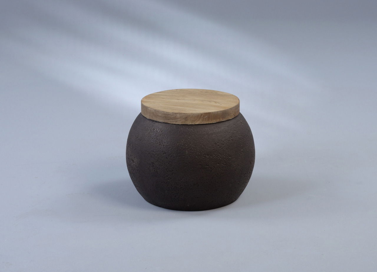 Runder Beistelltisch mit dunklem, strukturiertem Korpus und heller Holzplatte, seitliche Perspektive