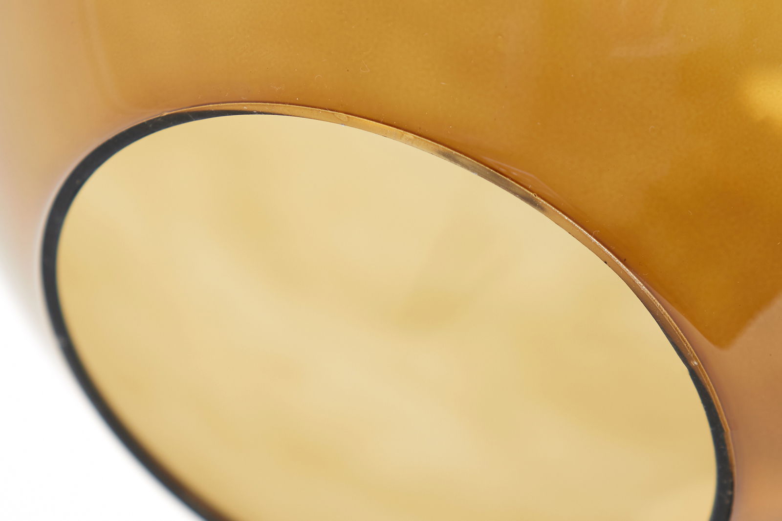 Nahaufnahme einer Hängeleuchte mit goldener Oberfläche, von unten betrachtet.