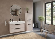 Modernes Badezimmer mit Waschtisch-Set für zwei Armaturen, runder Spiegel und minimalistischer Einrichtung, seitliche Perspektive.