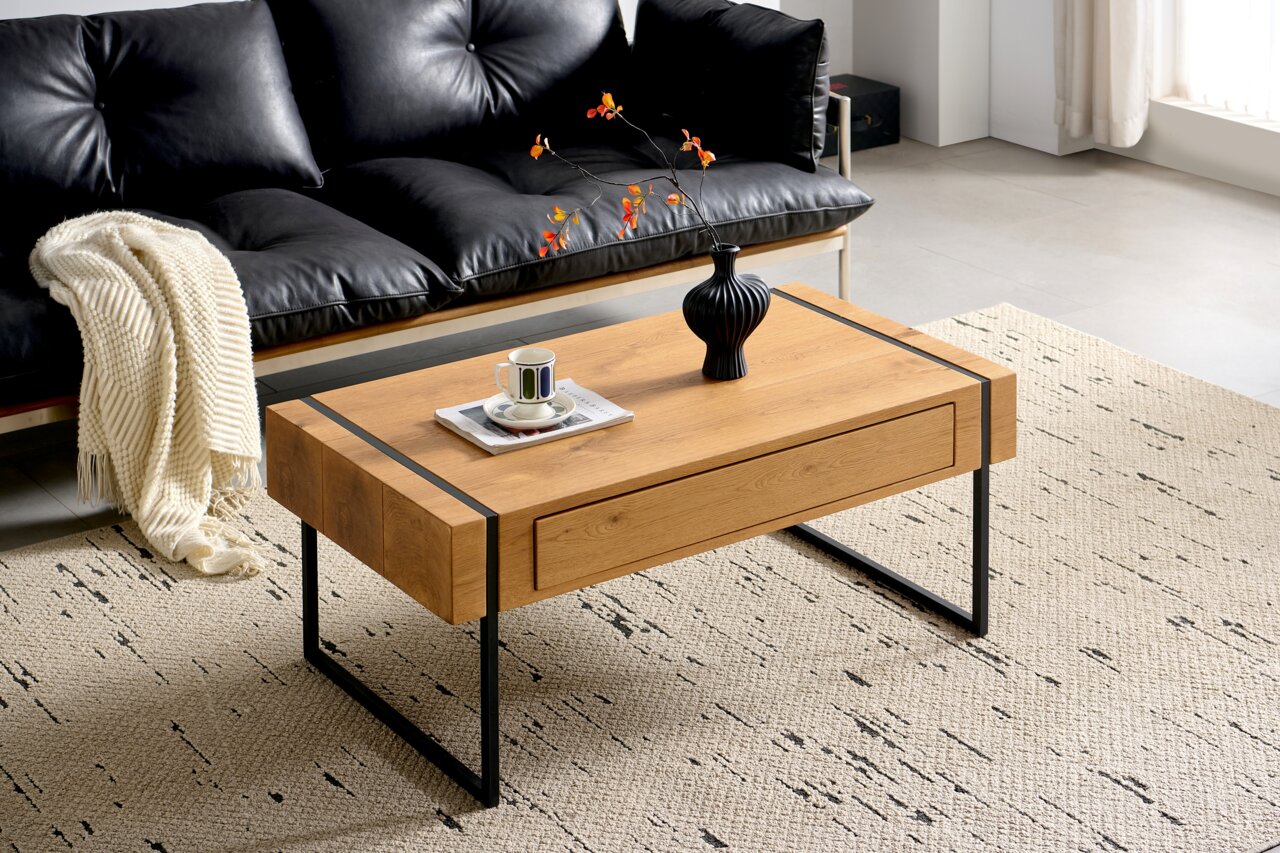 Z2 Salontafel NOEMIE Moderne houten salontafel met zwarte metalen poten, versierd met een vaas en een kopje, gezien vanuit de woonkamer met een zwarte leren bank.