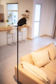 Moderne LED Stehleuchte in einem gemütlichen Wohnzimmer, seitliche Perspektive