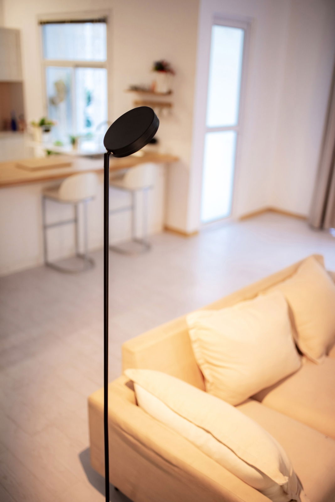 Moderne LED Stehleuchte in einem gemütlichen Wohnzimmer, seitliche Perspektive