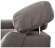 Nahaufnahme einer verstellbaren Kopfstütze eines Sofas in grauem Stoff.