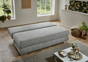 Modernes graues Schlafsofa/Polsterbett in einem hellen Wohnzimmer, Perspektive: leicht erhöhte schräge Seitenansicht von vorne.