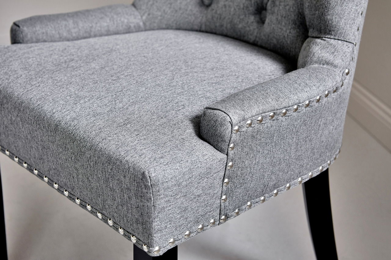Grauer Polsterstuhl mit Nietenverzierung, seitliche Perspektive