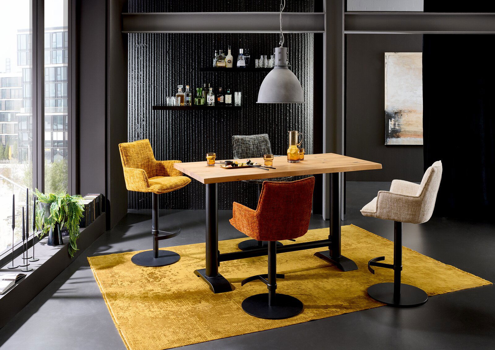 Valdera Tresentisch MOJITO Moderner Tresentisch mit vier bunten Barhockern in einem stilvollen Raum, seitliche Perspektive.