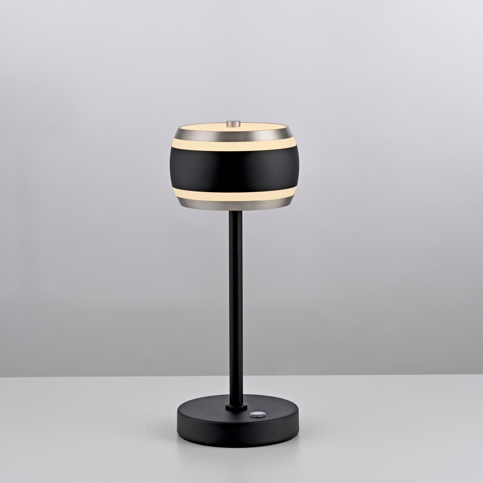 Moderne accu-tafellamp in zwart met cilindrische lampenkap, zijaanzicht.