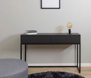 Schwarze Konsole mit zwei Schubladen, darauf eine Lampe und Bücher, aus frontaler Perspektive fotografiert.