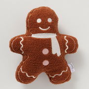 Kissen in Form eines Lebkuchenmanns aus braunem Polyester mit weißen und rosa Details, von oben betrachtet.