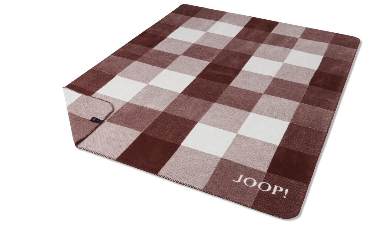 JOOP! Wohndecke J! 150x200cm Mesh Rote und weiße karierte Decke mit dem Schriftzug 'JOOP!' in der Ecke, aus schräger Vogelperspektive fotografiert.