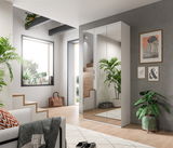 Moderne Garderobenkombination mit Spiegeltüren in einem hellen, stilvollen Raum mit Pflanzen und dekorativen Elementen, seitliche Perspektive.