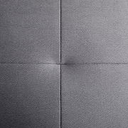 Nahaufnahme einer grauen, texturierten Polsteroberfläche mit sichtbaren Nähten in quadratischer Anordnung, von oben betrachtet.