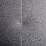 Nahaufnahme einer grauen, texturierten Polsteroberfläche mit sichtbaren Nähten in quadratischer Anordnung, von oben betrachtet.