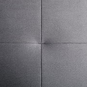 Nahaufnahme einer grauen, texturierten Polsteroberfläche mit sichtbaren Nähten in quadratischer Anordnung, von oben betrachtet.