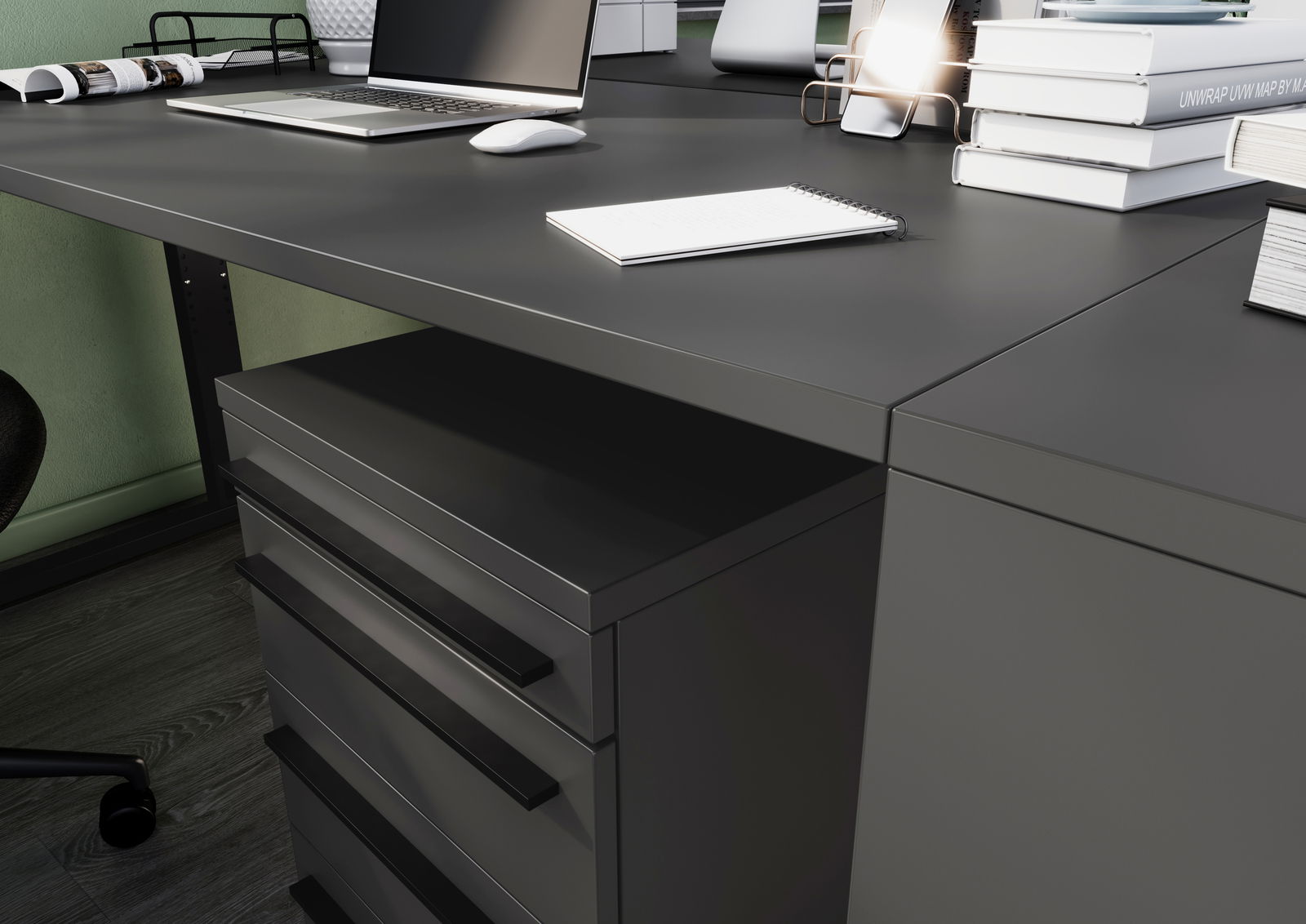Moderner Schreibtisch mit Laptop, Notizbuch und Schubladen aus der Perspektive von schräg oben.
