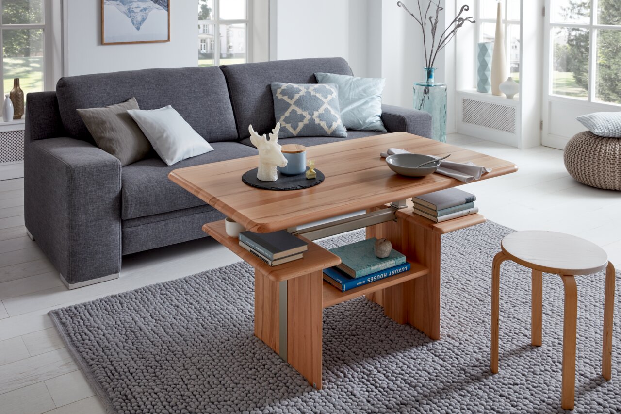 Moderner Couchtisch aus Holz in einem gemütlichen Wohnzimmer, seitliche Perspektive.