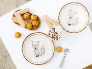 Kinder-Geschirrset mit Fuchs- und Alphabetmotiv, bestehend aus zwei Tellern und einer Tasse mit Kakao und Marshmallows, dekorativ mit Gebäck und Löffel aus der Vogelperspektive arrangiert