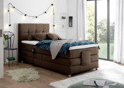 Gemütliches Boxspringbett in einem modernen Schlafzimmer, seitliche Perspektive