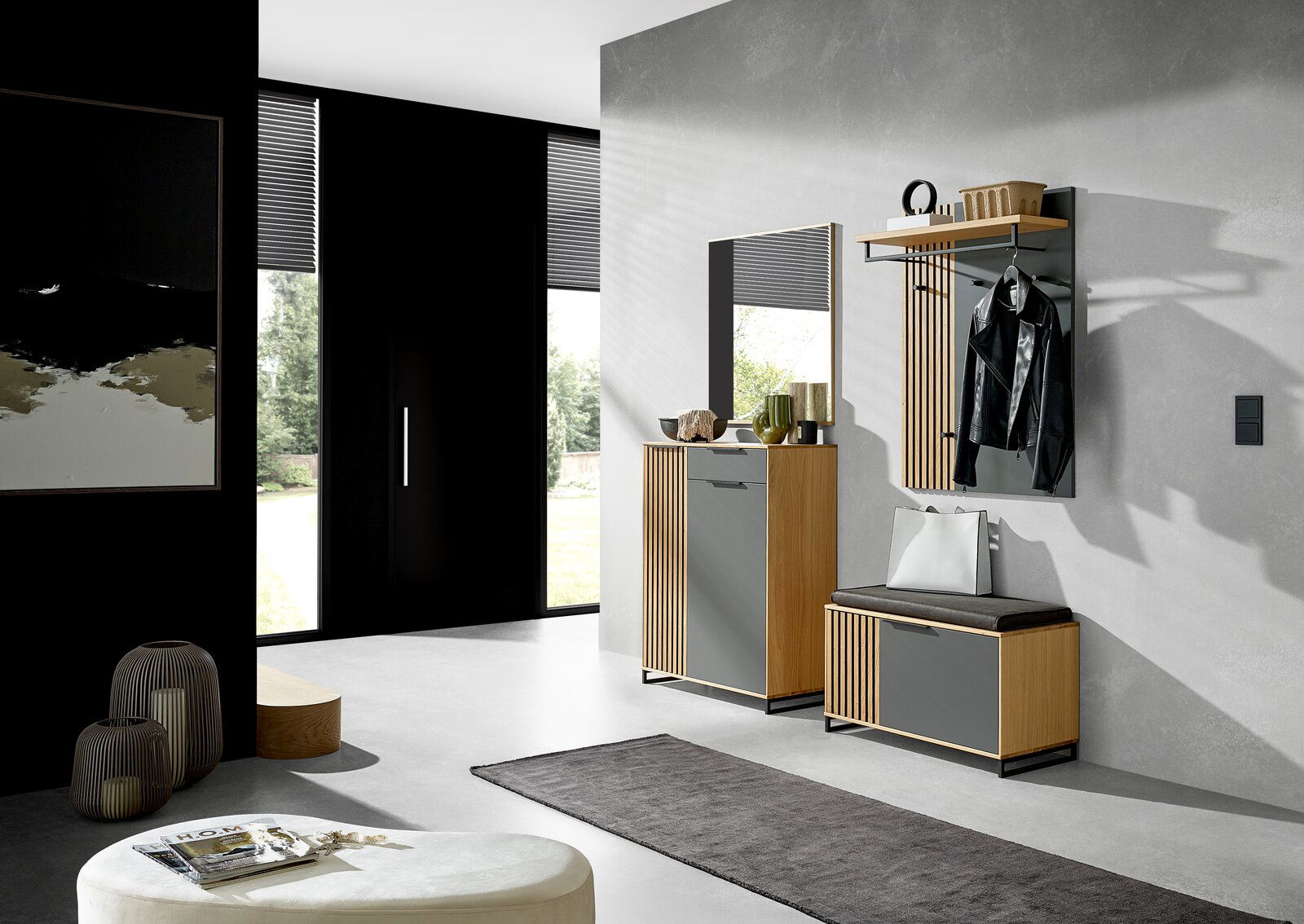 Moderner Eingangsbereich mit Garderobenmöbeln in Holzoptik und grauen Fronten, bestehend aus einem Spiegel, einem Schuhschrank, einer Garderobenbank und einem Garderobenpaneel. Perspektive von schräg vorne.