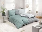 Bettwäsche-Set in einem modernen Schlafzimmer mit Tageslicht, bestehend aus Kissen und Decken in Grün- und Grautönen mit geometrischem Muster, seitliche Perspektive.