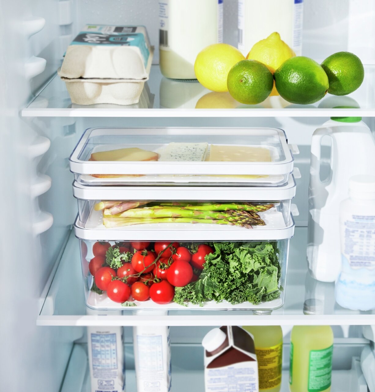 Kühlschrankorganizer 3-teilig, gefüllt mit frischem Gemüse und Käse, in einem Kühlschrank von vorne betrachtet.