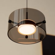 Moderne LED-Hängeleuchte mit rauchgrauem Glasschirm, von unten betrachtet.