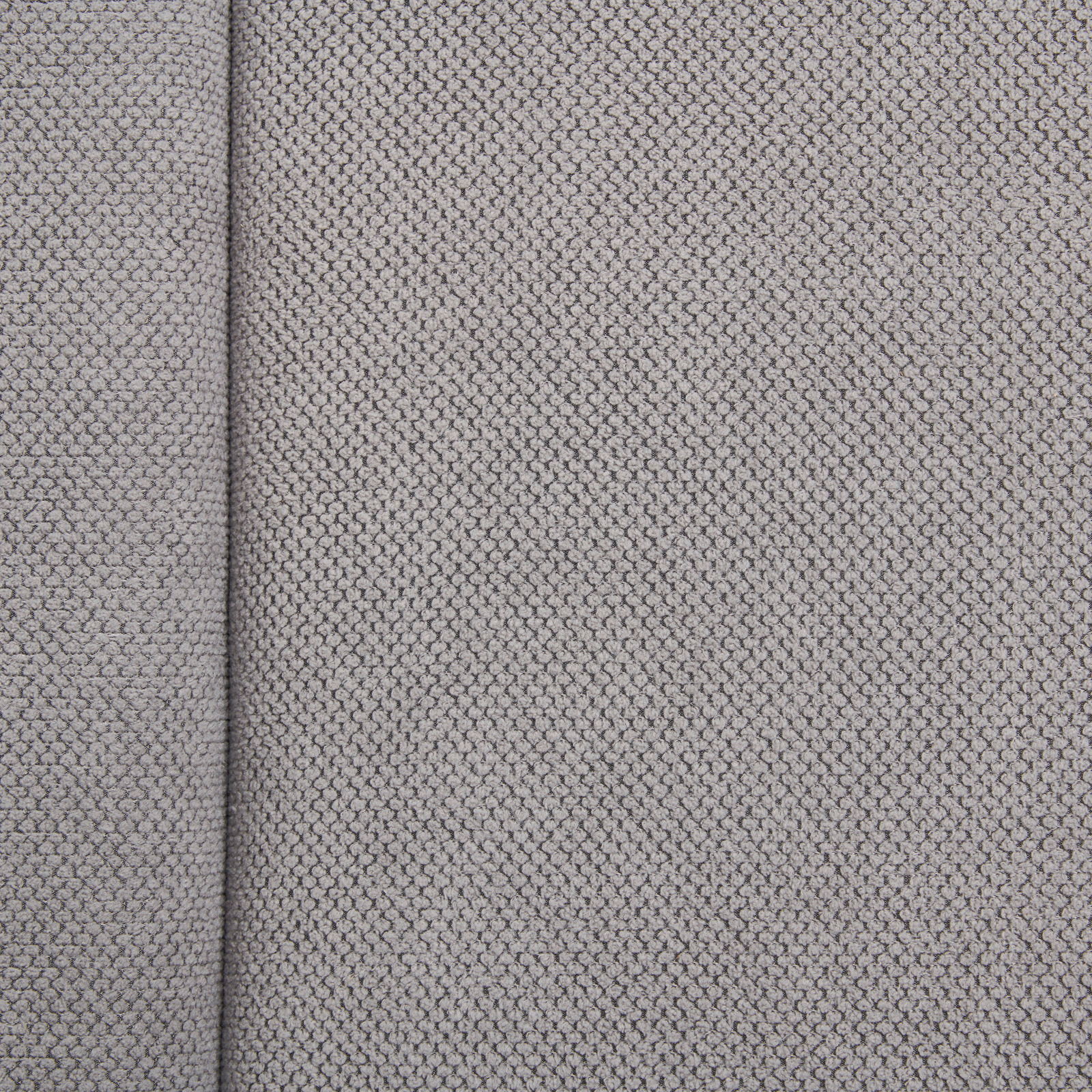 Nahaufnahme eines grauen Stoffes mit feiner Webstruktur, von oben betrachtet.