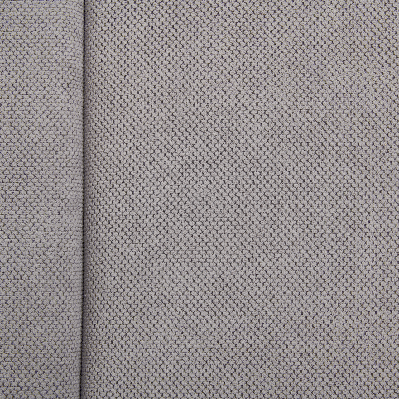Nahaufnahme eines grauen Stoffes mit feiner Webstruktur, von oben betrachtet.