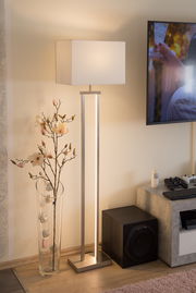 Moderne Stehleuchte mit rechteckigem Lampenschirm in einem gemütlichen Wohnzimmer, seitliche Perspektive.