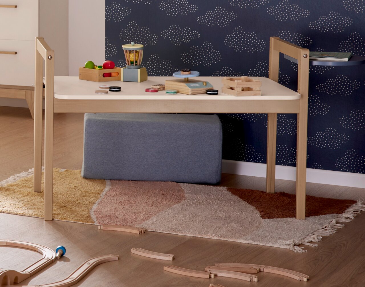 Tischplatte Tiny Table in einem Kinderzimmer, frontal fotografiert, mit Spielzeug und einem Teppich darunter.