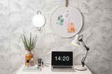 Rundes Memo-Board an der Wand mit Pflanzenmotiv, dekoriert mit Notizen und Karten, aus seitlicher Perspektive.