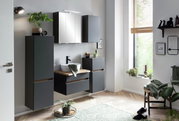 Modernes Waschtisch-Set in einem stilvollen Badezimmer mit grauen Schränken, einem Spiegel und Pflanzen, seitliche Perspektive.